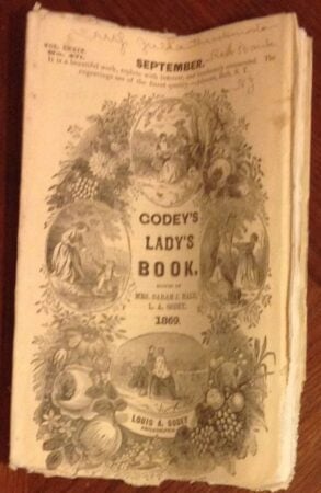 An old, sepia-toned cover of Godeys Ladys Book from September 1869 features ornate illustrations of women, flowers, and fruit, with the title and editor names prominently displayed in the center.