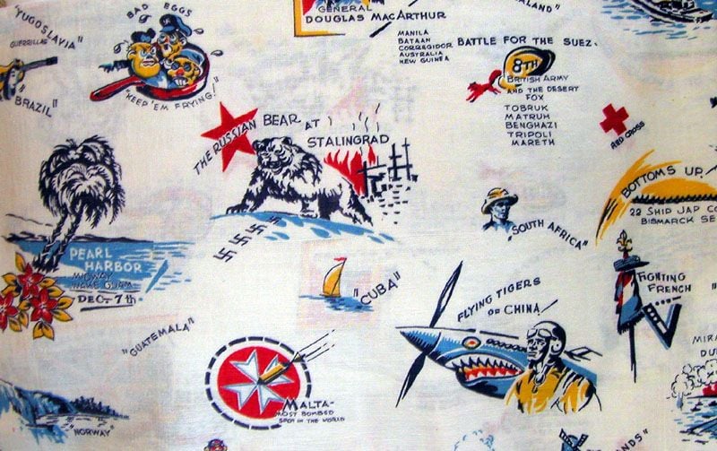 Vintage map-themed fabric featuring illustrated scenes and labels from World War II, including a bear at Stalingrad, Pearl Harbor, a shark-faced plane, military figures, and various geographic locations.