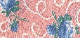 Pink fabric with white swirling patterns and blue flowers with green leaves printed on it. The texture of the fabric is visible, giving a slightly woven appearance.