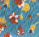 A close-up of blue fabric with a floral pattern featuring red and white flowers and yellow leaves. The texture of the fabric is visible.