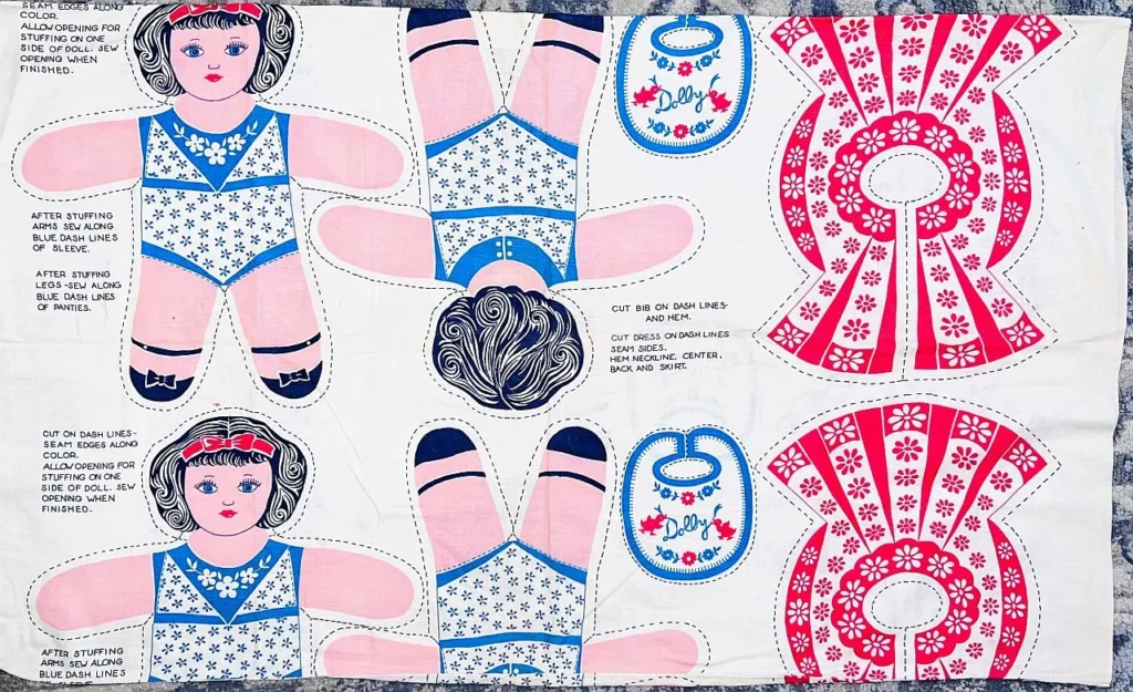 Fabric panel with printed cut-outs for making a Snow White doll, including doll parts, dress, and shoes, with sewing instructions and floral blue, pink, and white patterns.