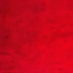 A close-up of a red textured fabric, showing visible weave lines and slight creases throughout the surface.