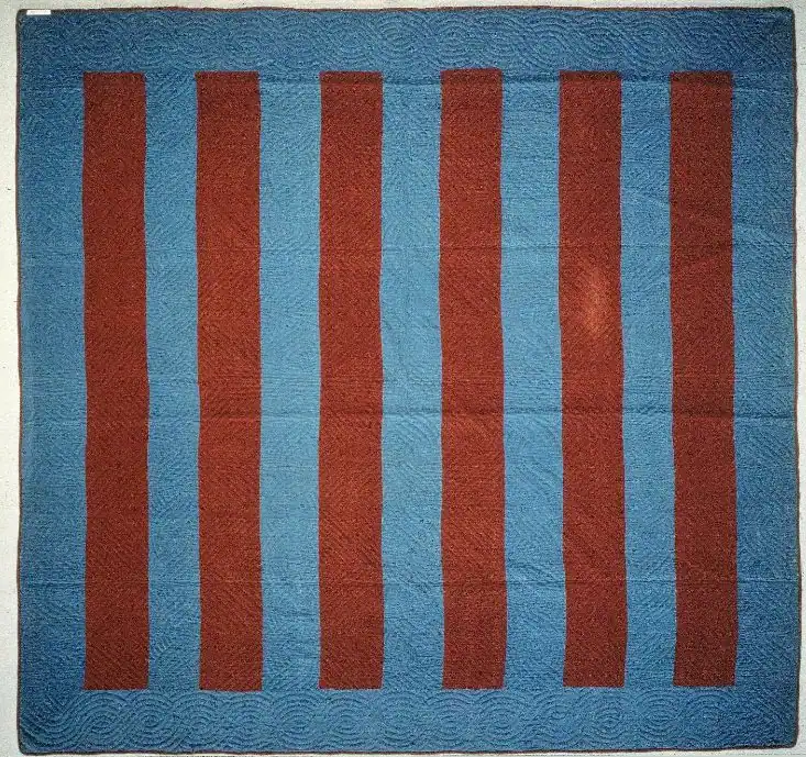 Amish-Bars-Quilt A quilt with six vertical, rectangular maroon stripes on a blue background, bordered by a wider blue frame. The pattern is simple and geometric.