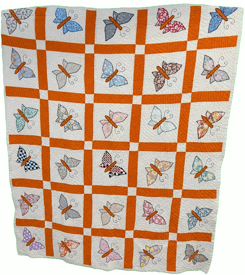 A handmade quilt featuring multicolored butterfly patterns in each white square, bordered by orange sashing and white cornerstones, arranged in a grid.
