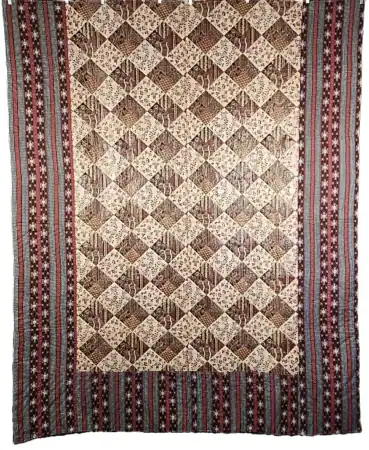 Preprinted-Patchwork-1830 A patterned quilt featuring a central grid of brown and beige diamond shapes, bordered by vertical red, white, and blue striped designs with star motifs..