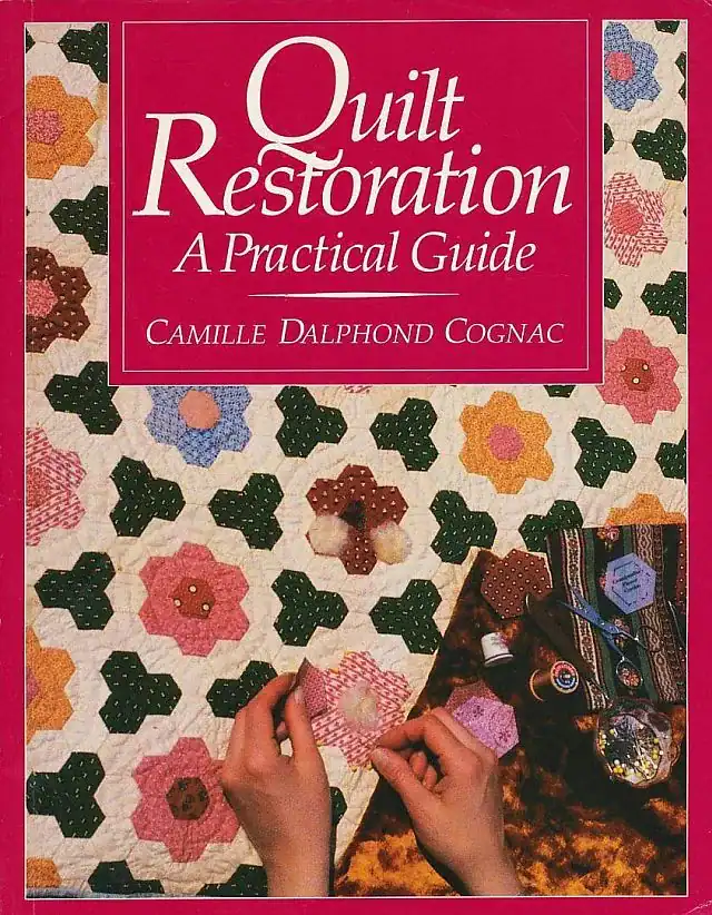 Book cover titled Quilt Restoration: A Practical Guide by Camille Dalphond Cognac. The background features a colorful patchwork quilt and a persons hands working on a quilt piece.