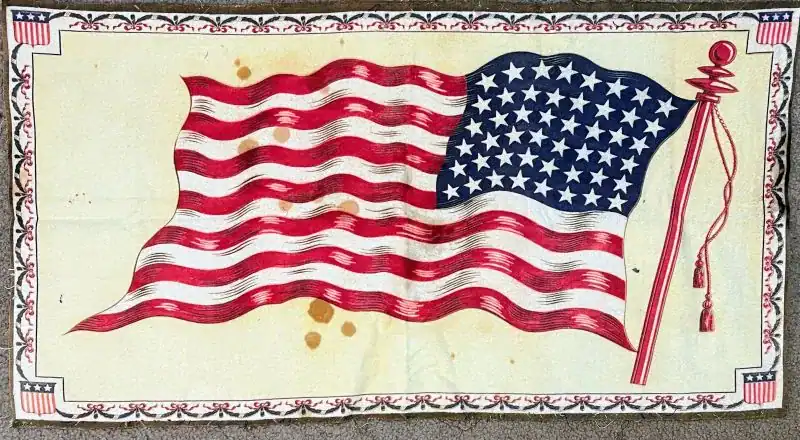 A vintage, slightly stained illustration of the U.S. flag with 48 stars, waving on a red flagpole, bordered by a decorative pattern featuring small American flag motifs.