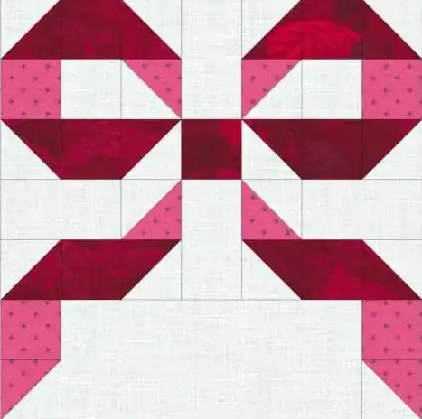 A quilt block featuring red and pink geometric shapes on a white background, forming a symmetrical bow-like pattern with square and triangle pieces.
