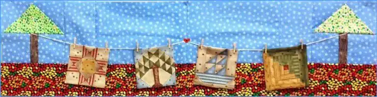 A quilted fabric scene features four colorful Faux Patchwork squares hanging on a string between two green trees, set against a blue sky and patterned ground.