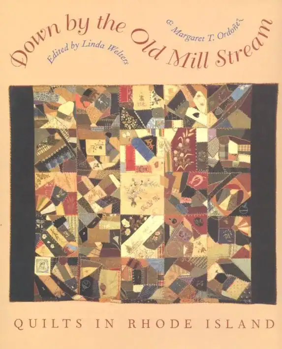 Book cover titled Down by the Old Mill Stream: Quilts in Rhode Island with a colorful patchwork quilt in the center and decorative text on a peach background.