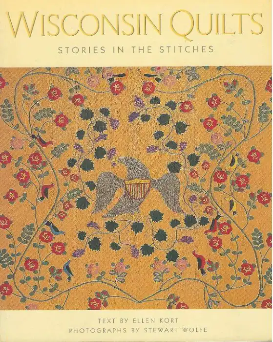 Book cover titled Wisconsin Quilts: Stories in the Stitches, featuring an intricate quilt design with flowers, leaves, and a bird. Text by Ellen Kort, photographs by Stewart Wolfe.