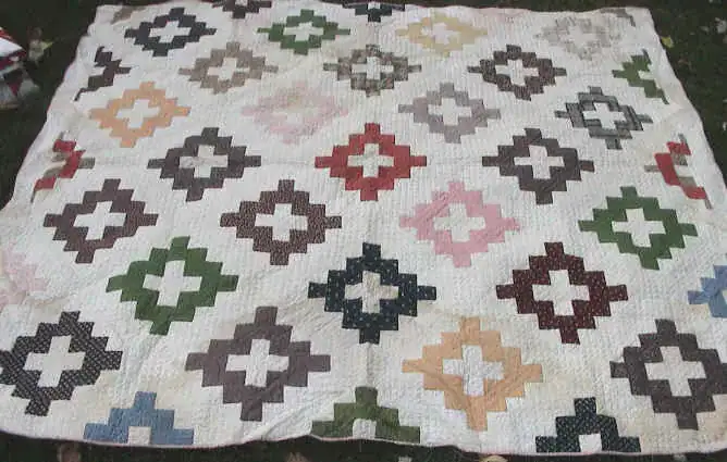 Antique album block quilt signed and dated 1852, with pink, green, brown and blue cross-shaped blocks on a white ground