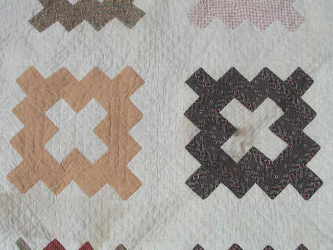 Close-up of two album blocks in tan and brown prints on the 1852 quilt