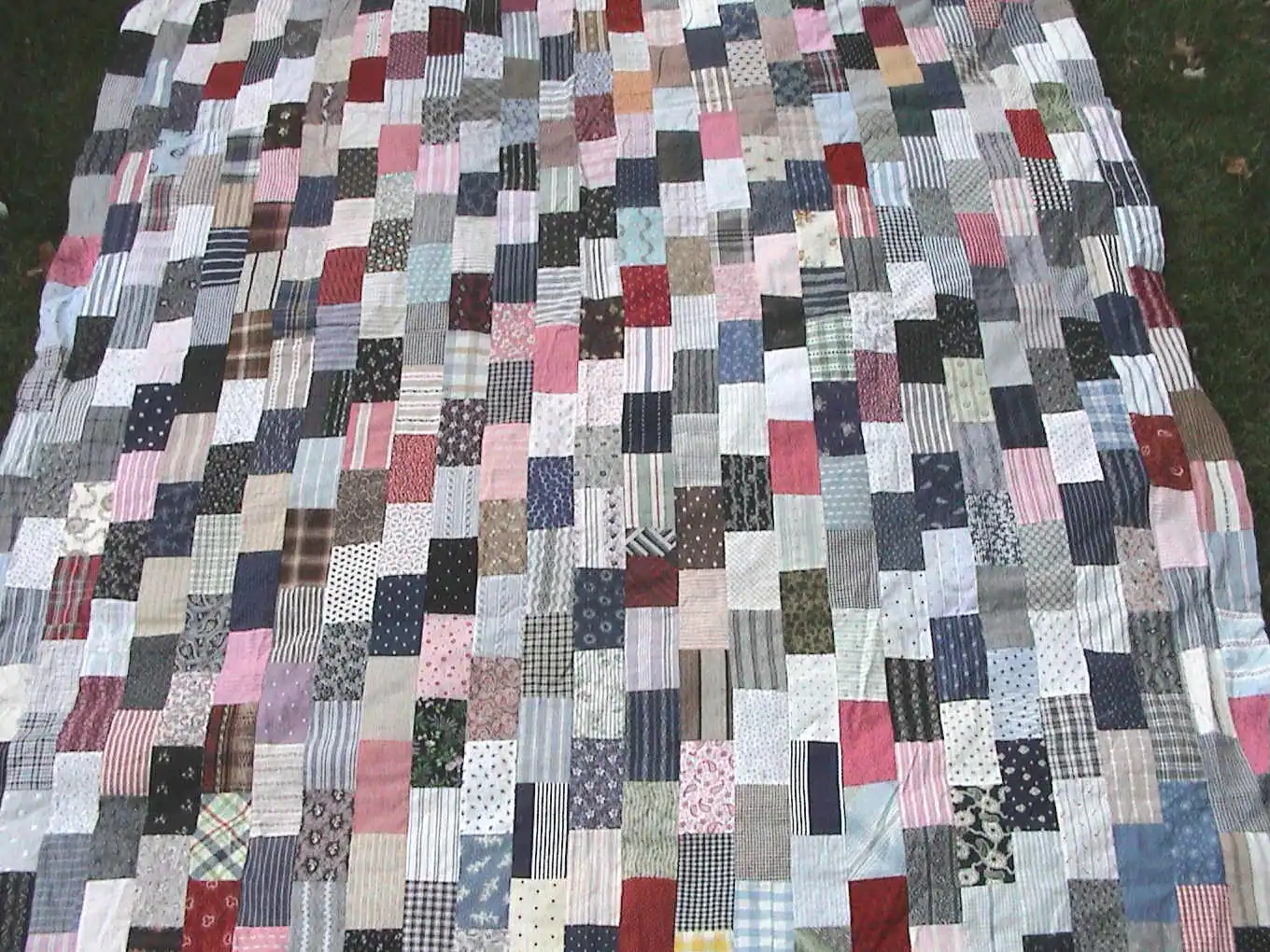 Scrappy brick block quilt top made of many small rectangles in varied prints and plaids