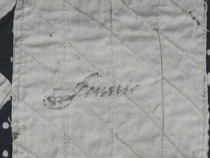 Ink name written in a quilted white block of the 1878 doll quilt