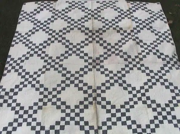 Indigo and white Double Irish Chain quilt laid on grass