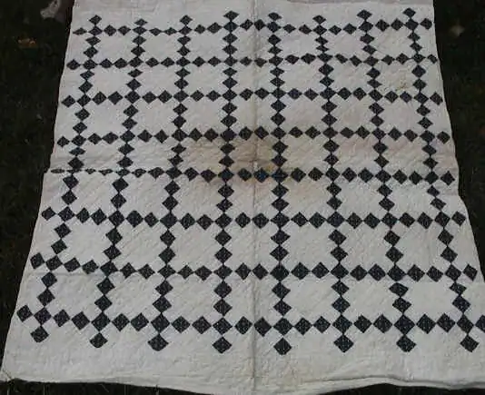 Indigo and white Single Irish Chain quilt with dotted blue squares and some water staining