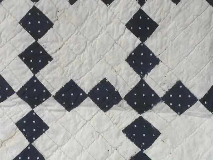 Close-up of dotted indigo squares forming the chain on the Single Irish Chain quilt
