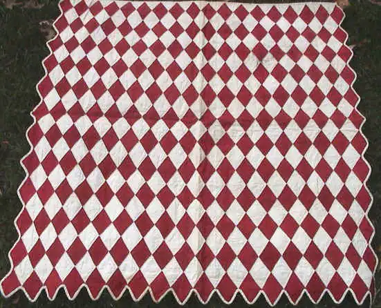 Small red and white diamond doll quilt with a scalloped edge