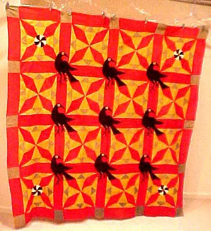 Pennsylvania Dutch style quilt top in red, yellow and green pieced blocks with black appliqued crows
